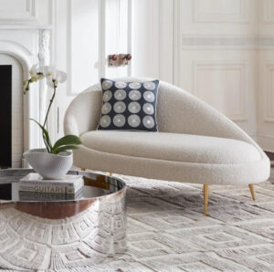 beautiful-glamorous-chaise-reading-chair-with-rounded-backrest-and-armrest-white-boucle-uphosltery-with-tapered-golden-legs-genuine-jonathan-adler-furniture-bedroom